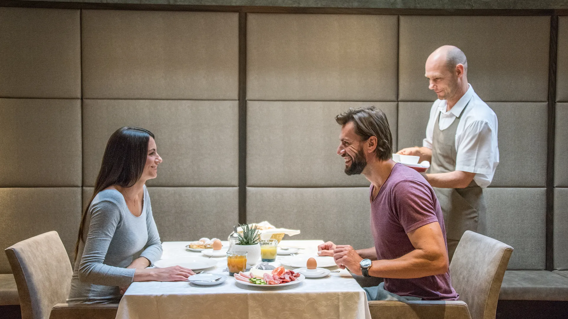 Frühstücksservice im Restaurant mit Gästen, gedeckter Tisch und Servicemitarbeiter in Kiens